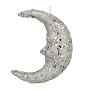 Silver glittery moon-shaped candle on a white background