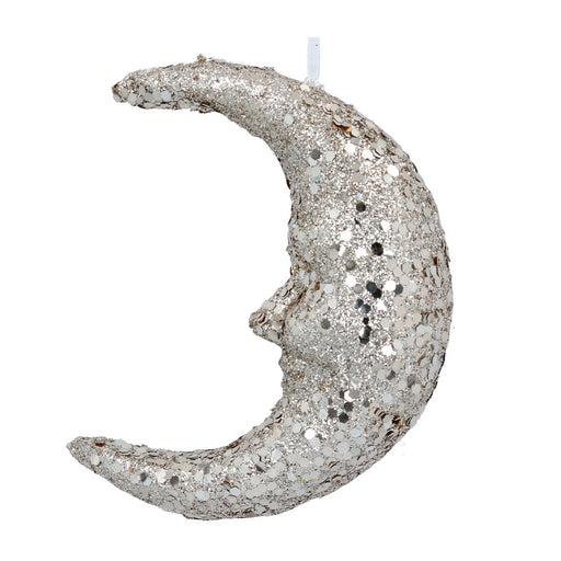 Silver glittery moon-shaped candle on a white background