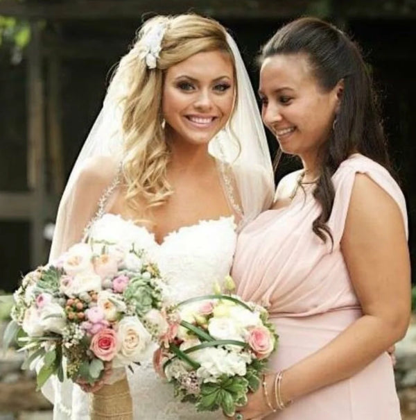 Bride and bridesmaid holding pastel wedding bouquets